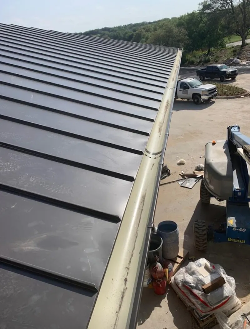 Standing seam panel and gutter detail on a metal roofing jobsite in Grandwood Park